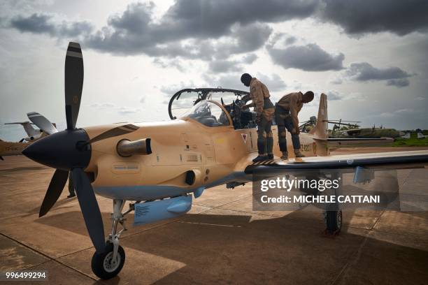 Two pilots get ready to take off with a new turboprop light attack aircraft "Super Tucano" newly arrived at the military air base in Bamako, on July...