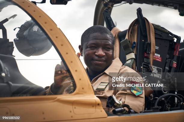 Malian army pilot gestures a peace sign as he gets ready to take off with one of the four new turboprop light attack aircrafts "Super Tucano" at the...
