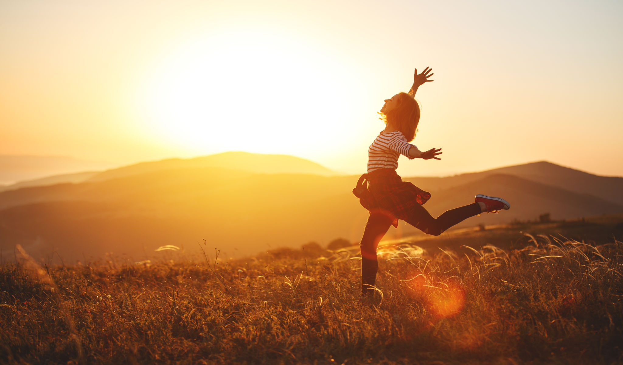 Happy woman jumping and enjoying life at sunset in mountains Happy woman jumping and enjoying life at sunset in mountains
