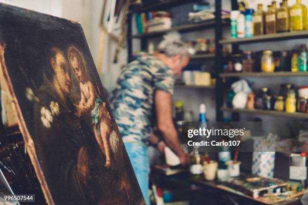 kunstenaar herstel van een oud schilderij - carlo107 stockfoto's en -beelden