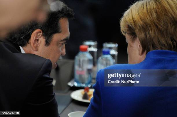 Greek PM Alexis Tsipras is seen speaking with German chancellor Angela Merkel during the 2018 NATO Summit in Brussels, Belgium on July 11, 2018.