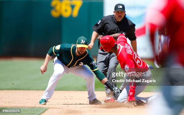 Jed Lowrie of the Oakland Athletics tags Jabari Blash of the Los Angeles Angels of Anaheim out at second at the Oakland Alameda Coliseum on June 16,...