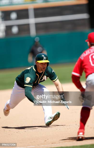 Chad Pinder of the Oakland Athletics slides safely into third during the game against the Los Angeles Angels of Anaheim at the Oakland Alameda...