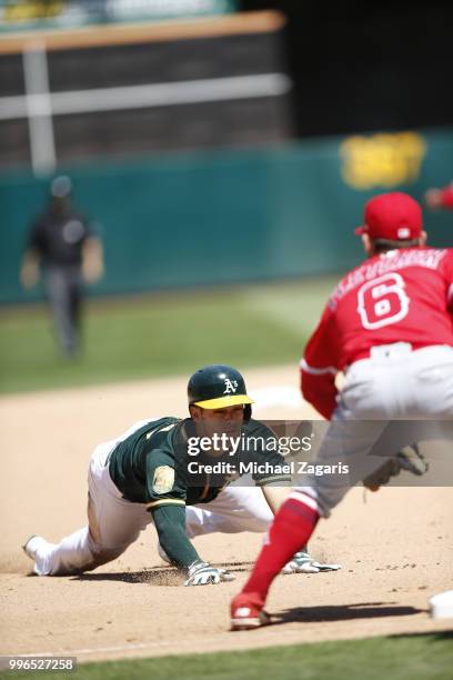 Chad Pinder of the Oakland Athletics slides safely into third during the game against the Los Angeles Angels of Anaheim at the Oakland Alameda...