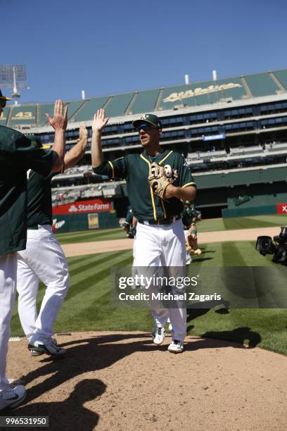 Stephen Piscotty of the Oakland Athletics celebrates with teammates on the field following the game against the Los Angeles Angels of Anaheim at the...