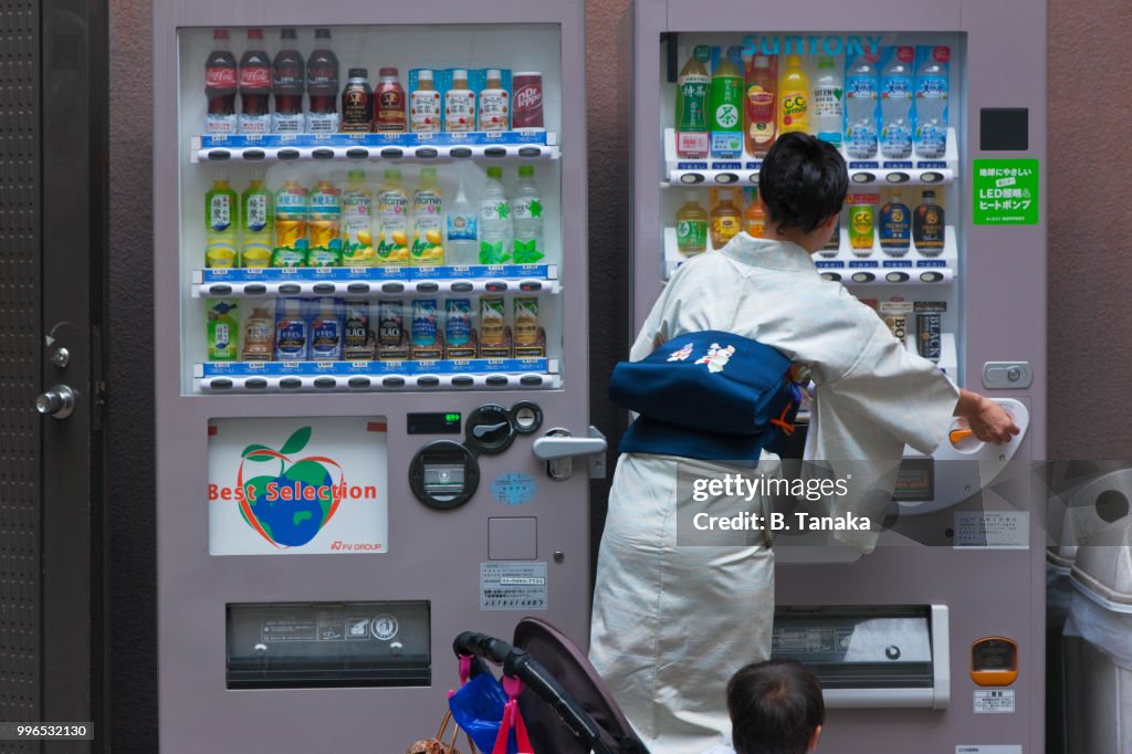 Young Mother in Traditional Kimono at Ginza Vending Machine in Tokyo, Japan