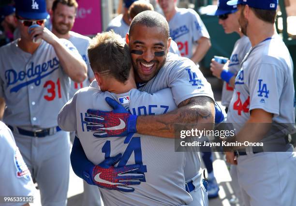 Enrique Hernandez hugs Matt Kemp of the Los Angeles Dodgers in the dugout before the game against the Los Angeles Angels of Anaheim at Angel Stadium...