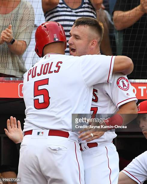 Albert Pujols is greeted by Mike Trout of the Los Angeles Angels of Anaheim after hitting a solo home run to tie the game in the sixth inning against...