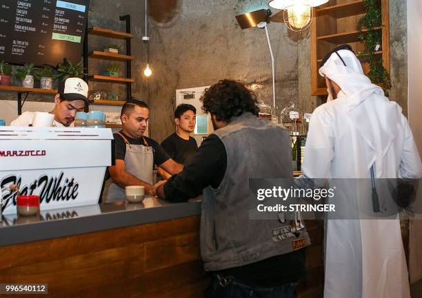 Customers queue for their orders at the "Flat White" cafe in the Qatari capital Doha's Tawar Mall on June 8, 2018. - Tawar Mall looks like any of...