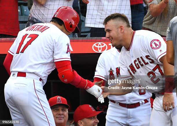 Shohei Otani is greeted by Mike Trout of the Los Angeles Angels of Anaheim at the dugout after hitting a pinch hit solo home run in the seventh...