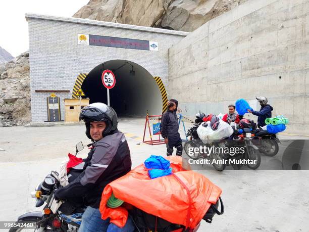 tourists on bike going to pass attabad lake tunnel - amir mukhtar 個照片及圖片檔