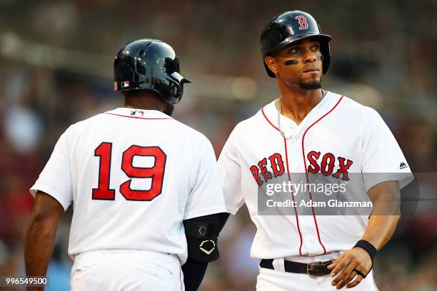 Xander Bogaerts high fives Jackie Bradley Jr. #19 of the Boston Red Sox after scoring in the second inning of a game against the Texas Rangers at...