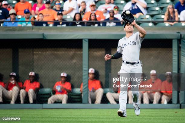 Giancarlo Stanton of the New York Yankees catches a fly ball hit by Tim Beckham of the Baltimore Orioles during the first inning at Oriole Park at...