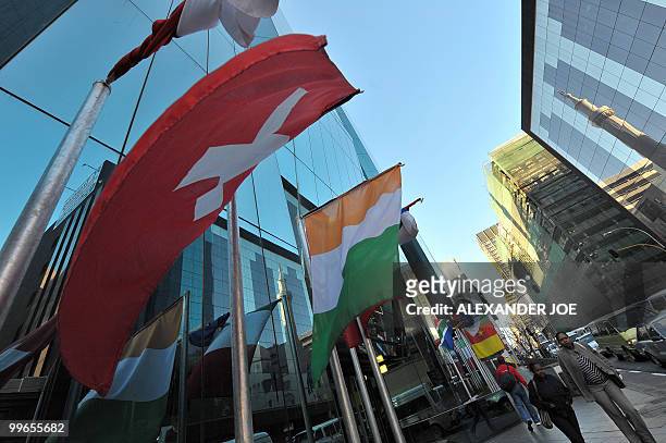 South Africans walking to work in Johannesburg on May 17, 2010 pass a building with the flags of the 32 countries that will compete for the Fifa...