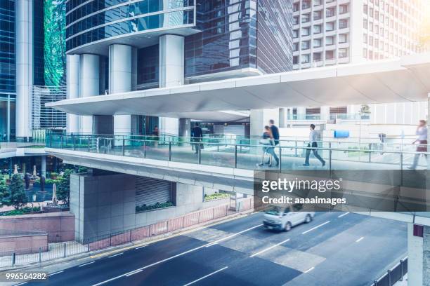 side view of commuters walking through covered footbridge - voetgangersbrug stockfoto's en -beelden