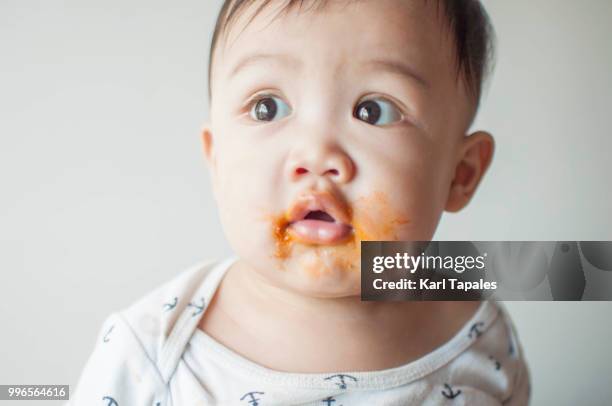a portrait of a baby boy with spagetti stains on his face - funny baby faces stock pictures, royalty-free photos & images