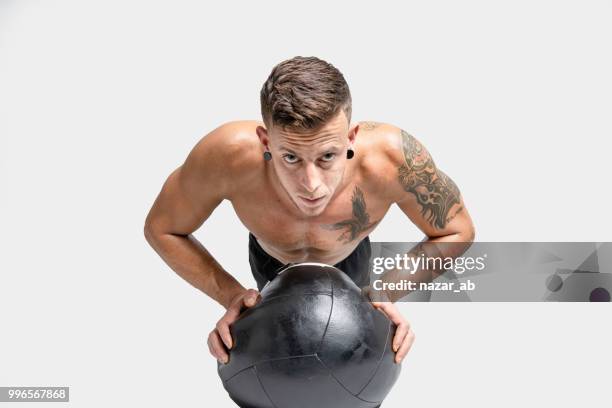 hombre joven con tatuajes haciendo push ups. - nazar fotografías e imágenes de stock