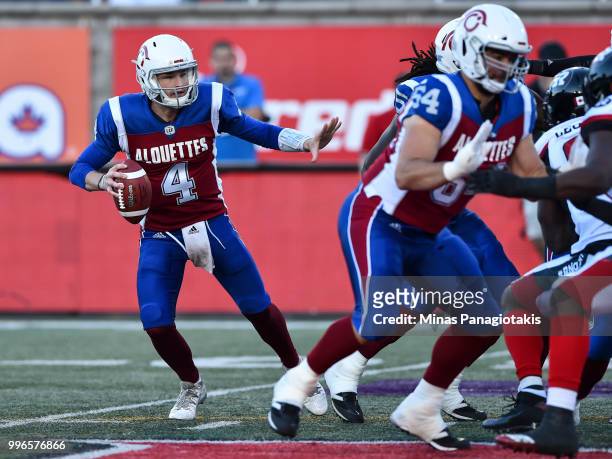 Quarterback Jeff Mathews of the Montreal Alouettes protects the ball against the Ottawa Redblacks during the CFL game at Percival Molson Stadium on...