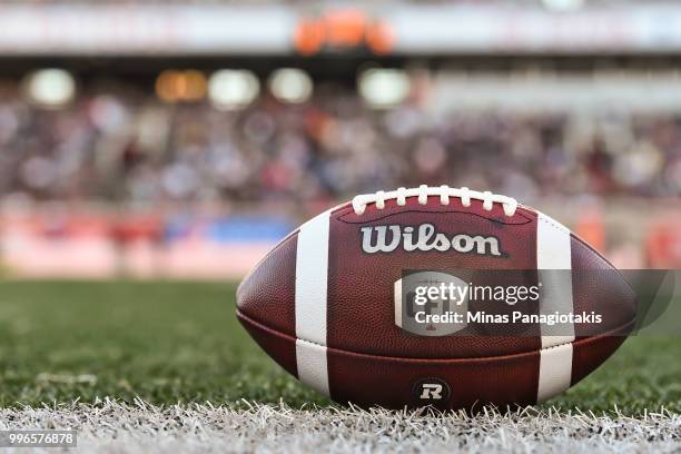 An official football sits on the field during the CFL game between the Montreal Alouettes and the Ottawa Redblacks at Percival Molson Stadium on July...