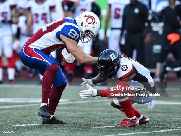 Defensive back Josh Johnson of the Ottawa Redblacks defends against fullback Patrick Lavoie of the Montreal Alouettes during the CFL game at Percival...