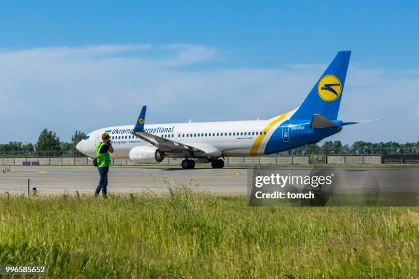 spotter taking photos of the aircraft of the ukraine international airlines at the boryspil airport, ukraine - ukraine international airlines stock pictures, royalty-free photos & images