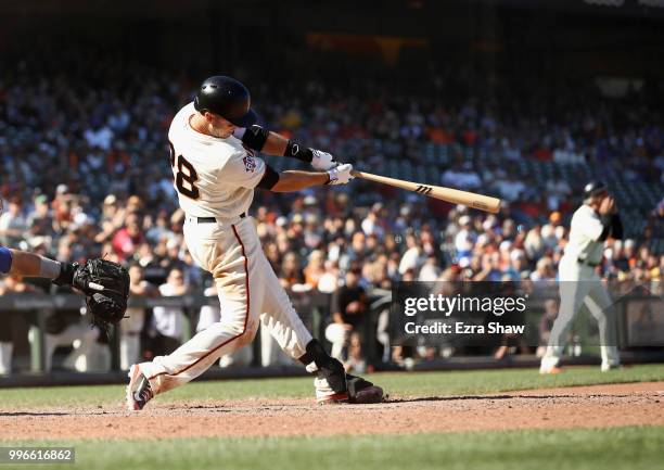 Buster Posey of the San Francisco Giants hits the game winning hit in the bottom of the 13th inning to beat the Chicago Cubs at AT&T Park on July 11,...