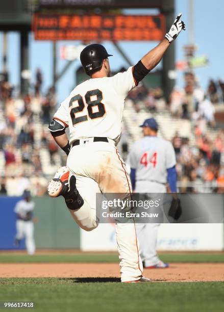 Buster Posey of the San Francisco Giants is reacts as he runs to first base after hitting the game winning hit in the bottom of the 13th inning to...