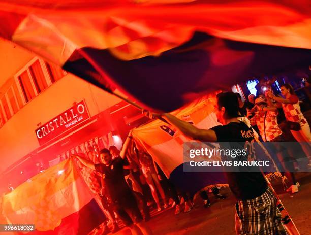 Bosnian Croats, citizens of North Western-Bosnian town of Livno, celebrate Croatia's win over England late on July 11 while watching the semi-final...