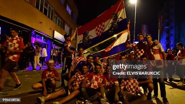 Bosnian Croats, citizens of North Western-Bosnian town of Livno, celebrate Croatia's win over England late on July 11 while watching the semi-final...