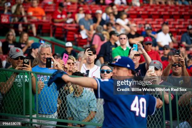Fans look on as Bartolo Colon of the Texas Rangers warms up before a game against the Boston Red Sox on July 11, 2018 at Fenway Park in Boston,...