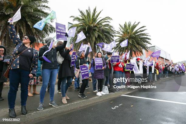 Nurses and Workers Union members hold signs during a strike at Wellington Regional Hospital on July 12, 2018 in Wellington, New Zealand. Thousands of...