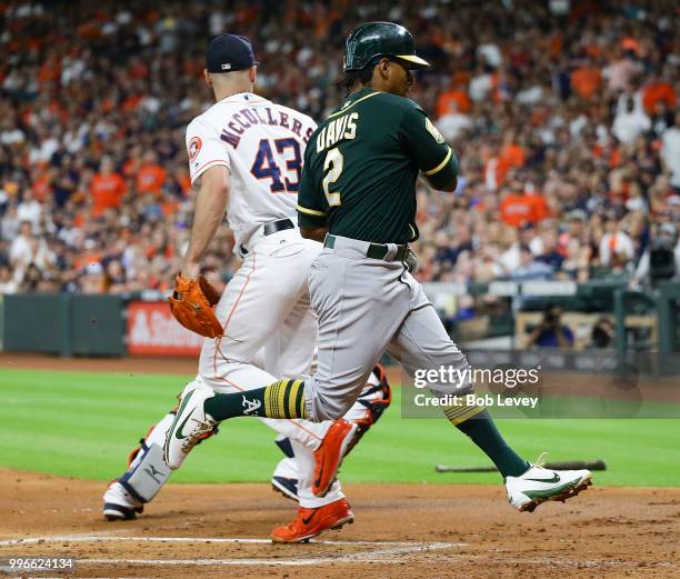Khris Davis of the Oakland Athletics scores in the first inning on a sacrifice fly by Matt Chapman of the Oakland Athletics at Minute Maid Park on...