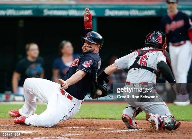 Yonder Alonso of the Cleveland Indians scores past Tucker Barnhart of the Cincinnati Reds on a single by Yan Gomes during the third inning at...