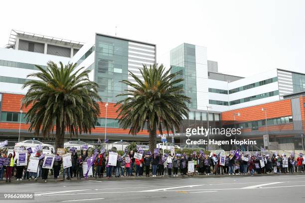 Nurses and Workers Union members hold signs during a strike at Wellington Regional Hospital on July 12, 2018 in Wellington, New Zealand. Thousands of...