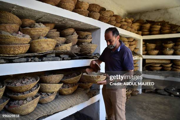 This photo taken on April 27, 2018 shows Italian archaeologist Luca Maria Olivieri looking through the remains of the destroyed Buddha in the town of...