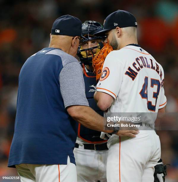 Houston Astros pitching coach Brent Strom talks with Lance McCullers Jr. #43 snd Tim Federowicz in the third inning against the Oakland Athletics at...