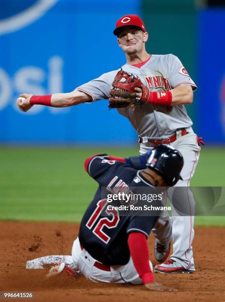 Scooter Gennett of the Cincinnati Reds forces out Francisco Lindor of the Cleveland Indians at second base and throws out Brandon Guyer at first base...