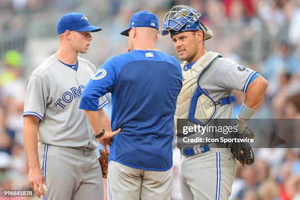 Blue Jays pitching coach Pete Walker talks things over with pitcher Sam Gaviglio and catcher Luke Maile during the game between Atlanta and Toronto...