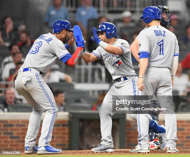 Devon Travis of the Toronto Blue Jays is congratulated by Lourdes Gurriel, Jr. #13 after hitting a grand slam in the seventh inning against the...
