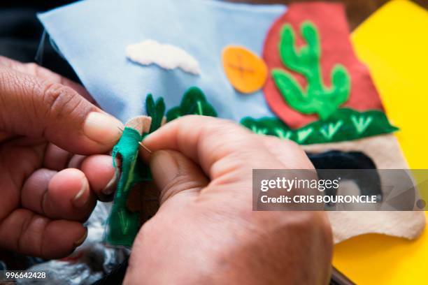 Woman displaced from her community in the Andes during Peru's conflict against the Maoist Shining Path guerrilla, works on an "Arpillera" -a...