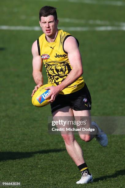 Jack Higgins of the Tigers runs with the ball during a Richmond Tigers AFL training session at Punt Road Oval on July 12, 2018 in Melbourne,...
