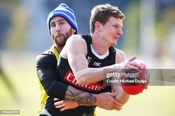 Jeremy Howe of the Magpies tackles Will Hoskin-Elliott of the Magpies Nathan Buckley speaks to the media during a Collingwood Magpies AFL press...