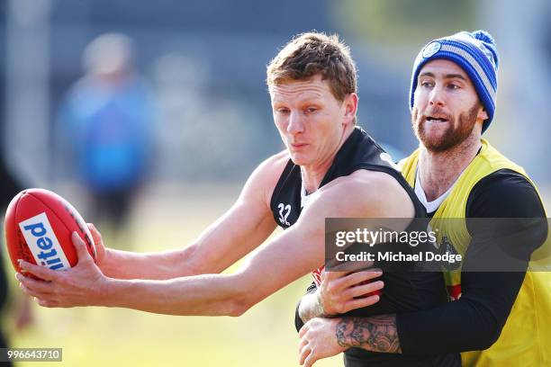 Jeremy Howe of the Magpies tackles Will Hoskin-Elliott of the Magpies Nathan Buckley speaks to the media during a Collingwood Magpies AFL press...