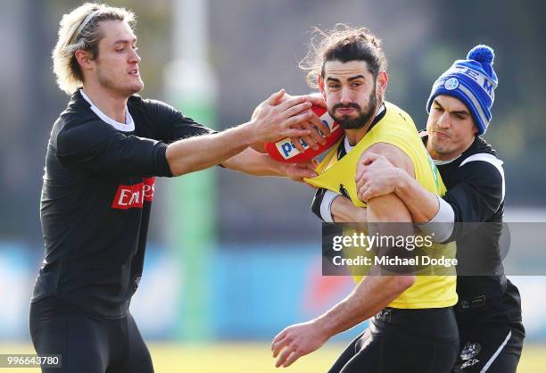 Darcy Moore of the Magpies and Brayden Maynard tackle Brodie Grundy of the Magpies during a Collingwood Magpies AFL press conference at the Holden...