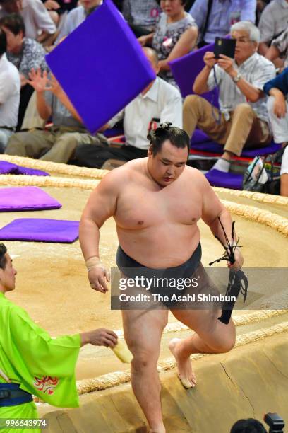 Mongolian yokozuna Kakuryu reacts while cushions are thrown after his defeat by Ikioi on day four of the Grand Sumo Nagoya Tournament at the...