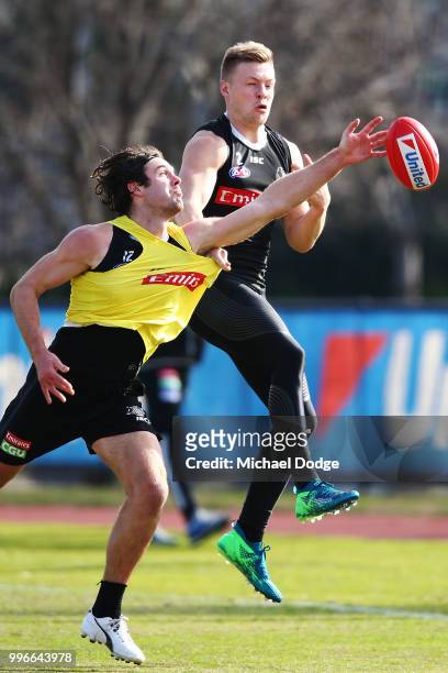 Matthew Scharenberg of the Magpies competes for the ball against Jordan de Goey of the Magpies during a Collingwood Magpies AFL press conference at...