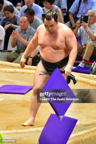 Mongolian yokozuna Kakuryu reacts while cushions are thrown after his defeat by Ikioi on day four of the Grand Sumo Nagoya Tournament at the...