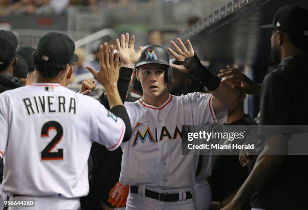 The Miami Marlins' Brian Anderson is congratulated by teammates after scoring on a sacrifice fly by Starlin Castro during the fourth inning against...