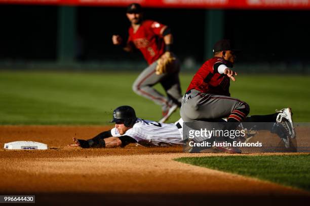 Trevor Story of the Colorado Rockies slides safely at second base as shortstop Ketel Marte of the Arizona Diamondbacks awaits the throw and second...