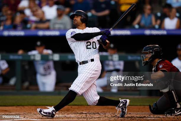 Ian Desmond of the Colorado Rockies hits a three-run home run as catcher Alex Avila of the Arizona Diamondbacks looks on during the first inning at...